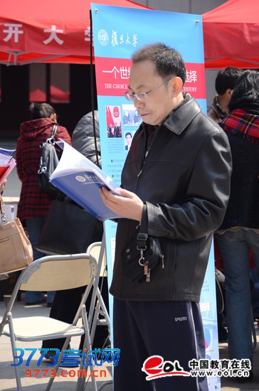 学生家长正在仔细阅读复旦大学高招资料