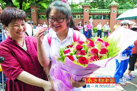 昨天,全国高考首日,广州市第七中学门口,从考场走出来的一名考生收到了妈妈的鲜花。 南都记者 林宏贤 摄